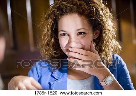 Stock Image - View of a smiling young African-American woman with long curly hair. Fotosearch
