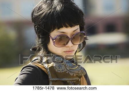 Stock Photo - View of a young Asian woman looking down. Fotosearch