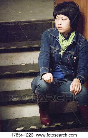 View of a young Asian woman sitting on steps View Large Photo Image Stock Image - View of a young Asian woman sitting on steps. Fotosearch
