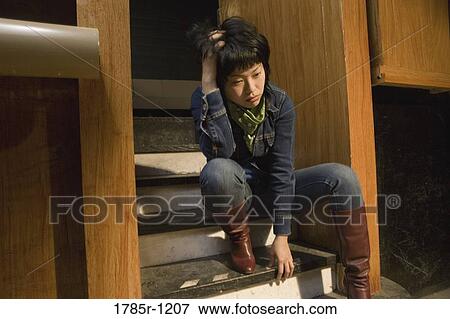 View of a young Asian woman sitting on steps View Large Photo Image Stock Photo - View of a young Asian woman sitting on steps. Fotosearch