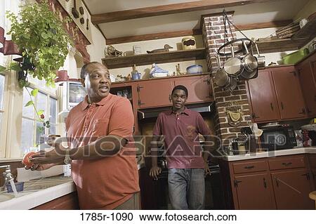 View of father and son conversing in kitchen View Large Photo Image Stock Image - View of father and son conversing in kitchen. Fotosearch