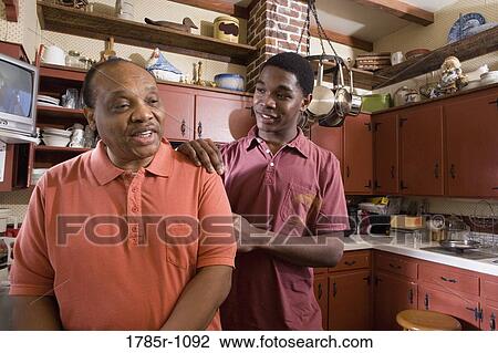 View of father and son conversing in kitchen View Large Photo Image Stock Image - View of father and son conversing in kitchen. Fotosearch
