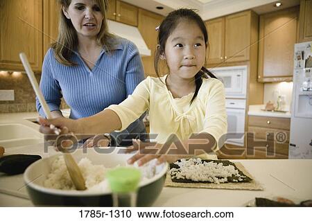 Woman and daughter in the kitchen making sushi View Large Photo Image Stock Image - Woman and daughter in the kitchen making sushi. Fotosearch