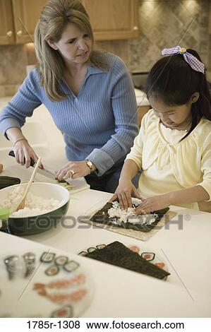 Woman and daughter in the kitchen making sushi View Large Photo Image Stock Photo - Woman and daughter in the kitchen making sushi. Fotosearch