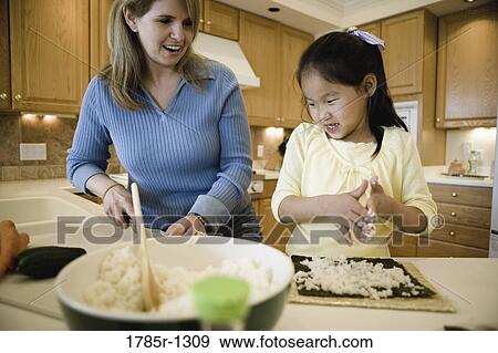 Woman and daughter in the kitchen making sushi View Large Photo Image Stock Photo - Woman and daughter in the kitchen making sushi. Fotosearch