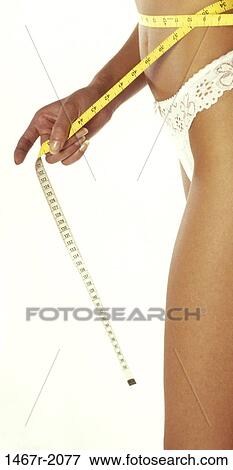 Stock Photo - Woman measuring her waist with a measuring tape. Fotosearch