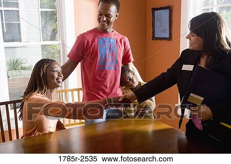 Stock Photography - Woman shaking hands with real estate broker. Fotosearch