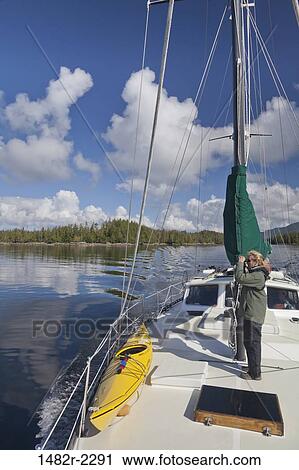 Stock Image - Woman standing on a SV Nawalak yacht from Orcas Island, Washington State, USA to British Columbia, Canada. Fotosearch
