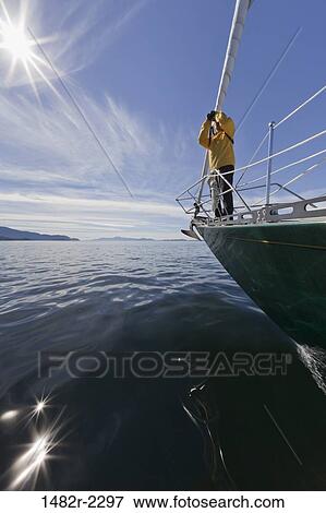 Stock Photo - Woman standing on a SV Nawalak yacht from Orcas Island, Washington State, USA to British Columbia, Canada. Fotosearch