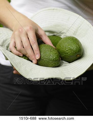 Woman's hand putting green avocado in a hat View Large Photo Image Stock Photo - Woman's hand putting green avocado in a hat. Fotosearch