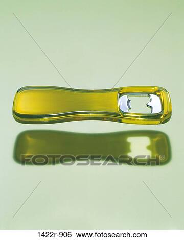 Yellow bottle opener floating above green surface View Large Photo Image Stock Photograph - Yellow bottle opener floating above green surface. Fotosearch