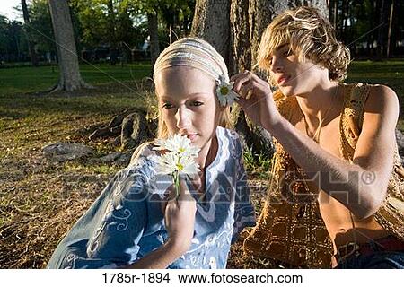 Young affectionate hippie couple relaxing under tree View Large Photo Image Picture - Young affectionate hippie couple relaxing under tree. Fotosearch