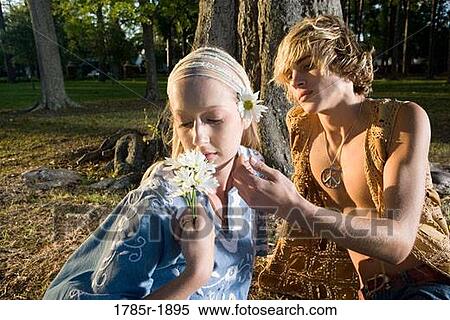 Stock Photography - Young affectionate hippie couple relaxing under tree. Fotosearch