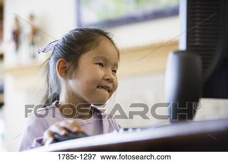 Young Asian giirl using computer View Large Photo Image Stock Photo - Young Asian giirl using computer. Fotosearch