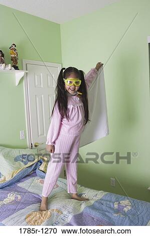 Young Asian girl in super-hero costume standing on bed View Large Photo Image Stock Image - Young Asian girl in super-hero costume standing on bed. Fotosearch