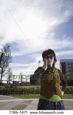 Young Asian woman adjusting her sunglasses View Large Photo Image Stock Image - Young Asian woman adjusting her sunglasses. Fotosearch