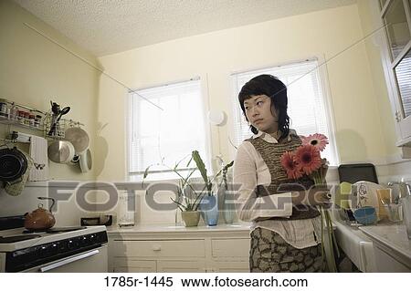 Young Asian woman holding flowers in apartment kitchen View Large Photo Image Stock Photography - Young Asian woman holding flowers in apartment kitchen. Fotosearch