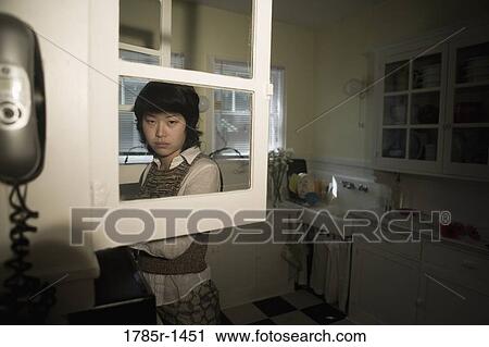 Young Asian woman in kitchen View Large Photo Image Stock Image - Young Asian woman in kitchen. Fotosearch
