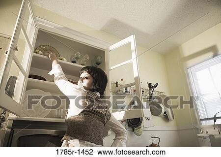 Young Asian woman in kitchen View Large Photo Image Stock Image - Young Asian woman in kitchen. Fotosearch