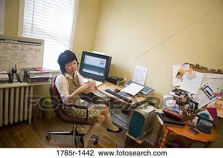 Young Asian woman working on computer at desk View Large Photo Image Stock Image - Young Asian woman working on computer at desk. Fotosearch