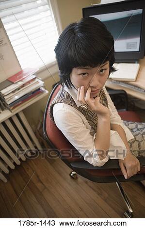 Young Asian woman working on computer at desk View Large Photo Image Stock Image - Young Asian woman working on computer at desk. Fotosearch