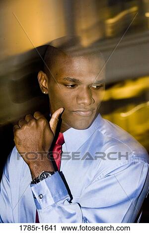 Young businessman looking away amidst streaks of lights in background View Large Photo Image Stock Image - Young businessman looking away amidst streaks of lights in background. Fotosearch