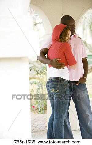 Stock Photography - Young couple embracing while standing in a gazebo. Fotosearch