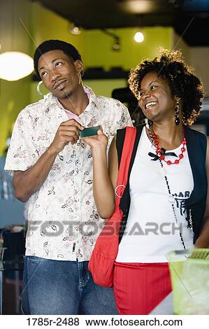 Young couple shopping in a boutique with credit card View Large Photo Image Stock Photo - Young couple shopping in a boutique with credit card. Fotosearch
