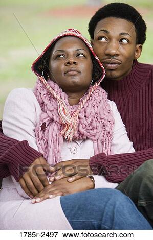Stock Photo - Young couple sitting together and embracing. Fotosearch