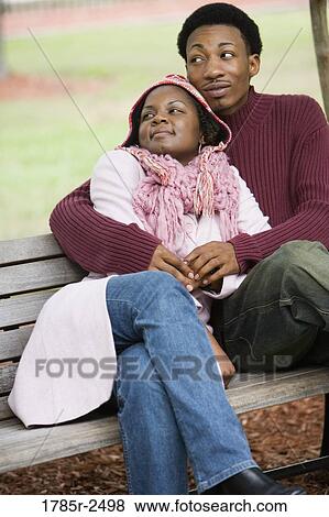 Stock Photo - Young couple sitting together and embracing. Fotosearch