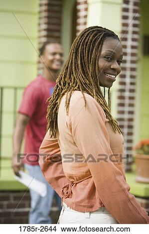 Young couple smiling outside house View Large Photo Image Picture - Young couple smiling outside house. Fotosearch