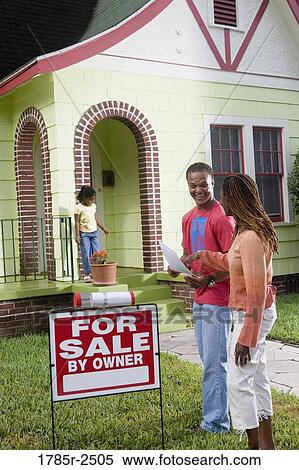 Young couple standing outside house by For Sale sign View Large Photo Image Stock Photography - Young couple standing outside house by For Sale sign. Fotosearch