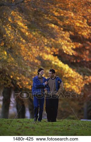 Young couple walking together View Large Photo Image Stock Photography - Young couple walking together. Fotosearch