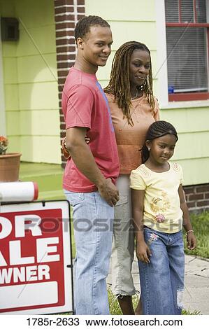 Young family standing outside house by "For Sale" sign View Large Photo Image Stock Image - Young family standing outside house by "For Sale" sign. Fotosearch