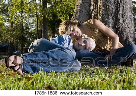 Stock Photograph - Young hippie couple relaxing under tree. Fotosearch