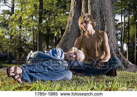 Young hippie couple relaxing under tree View Large Photo Image Stock Photography - Young hippie couple relaxing under tree. Fotosearch