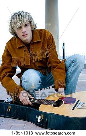 Stock Photo - Young male hippie with guitar. Fotosearch