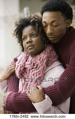 Stock Image - Young man embracing a woman. Fotosearch