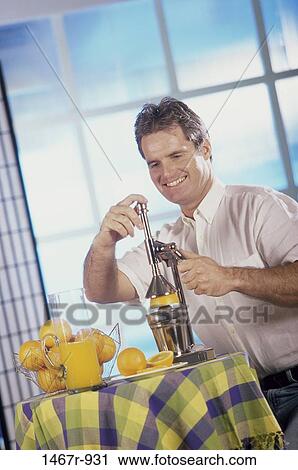 Young man making orange juice View Large Photo Image Stock Image - Young man making orange juice. Fotosearch
