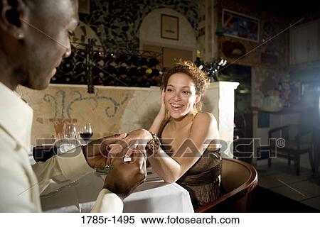 Young man putting engagement ring on woman's finger View Large Photo Image Stock Photography - Young man putting engagement ring on woman's finger. Fotosearch