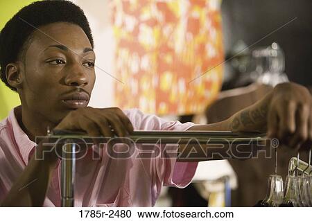 Young man standing in a boutique View Large Photo Image Stock Image - Young man standing in a boutique. Fotosearch