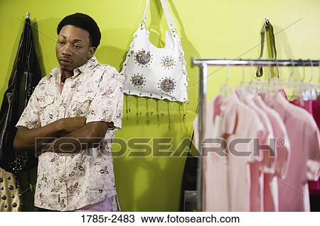 Young man standing in a women's clothing boutique View Large Photo Image Stock Image - Young man standing in a women's clothing boutique. Fotosearch