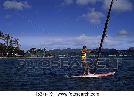 Young man windsurfing View Large Photo Image Stock Image - Young man windsurfing. Fotosearch
