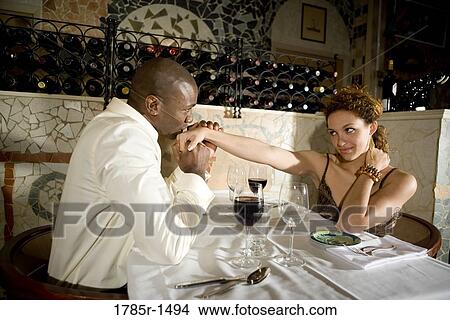 Young multi-ethnic romantic couple in restaurant View Large Photo Image Picture - Young multi-ethnic romantic couple in restaurant. Fotosearch