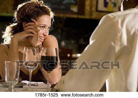 Stock Photography - Young multi-ethnic romantic couple in restaurant. Fotosearch