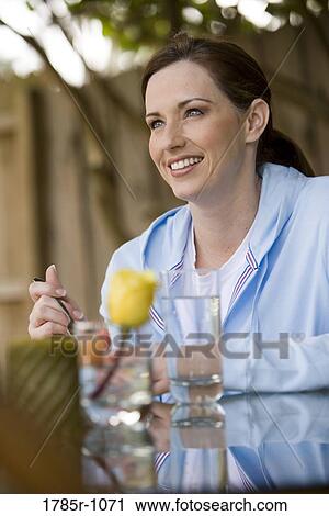 Young woman eating outdoors View Large Photo Image Stock Image - Young woman eating outdoors. Fotosearch