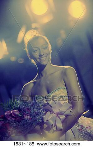 Young woman holding a bouquet of flowers smiling View Large Photo Image Stock Photography - Young woman holding a bouquet of flowers smiling. Fotosearch