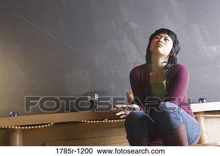 Young woman holding cigarette at a a bar View Large Photo Image Stock Image - Young woman holding cigarette at a a bar. Fotosearch