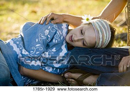 Stock Photo - Young woman in vintage 1960's hippie costumes with head on lap. Fotosearch