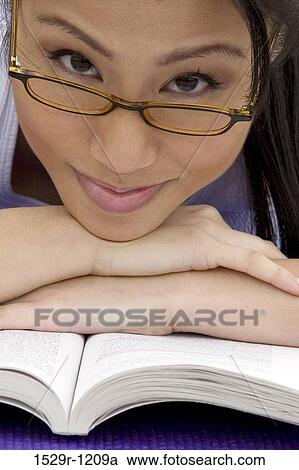 Young woman resting her head on a book View Large Photo Image Stock Image - Young woman resting her head on a book. Fotosearch
